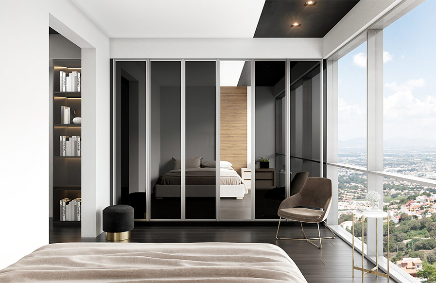 A cupboard design with mirrors in a stylish luxury bedroom with a wooden bed and patterned bedding - Beautiful Homes