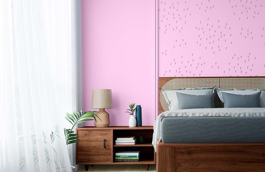 A modern bedroom interior with a bright yellow accent wall and patterned bedding - Beautiful Homes