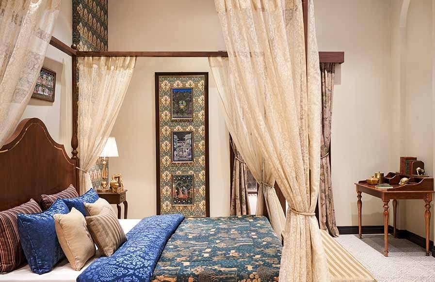 A neutral bedroom interior design in the traditional style with a patterned quilt and decorative pillows - Beautiful Homes