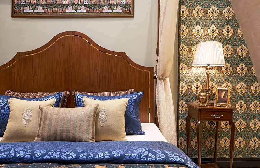 A neutral bedroom interior design in the traditional style with a patterned quilt and decorative pillows - Beautiful Homes