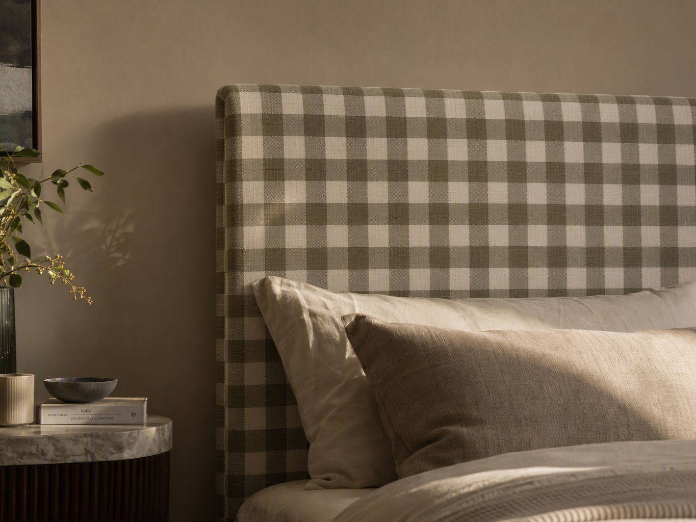 Upholstered bed headboard in a sage green and cream gingham pattern - Beautiful Homes