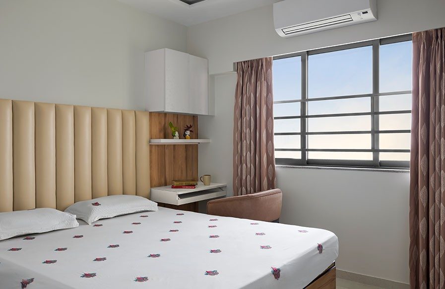 A modern all-white bedroom with a patterned wall and hanging pendant light - Beautiful Homes