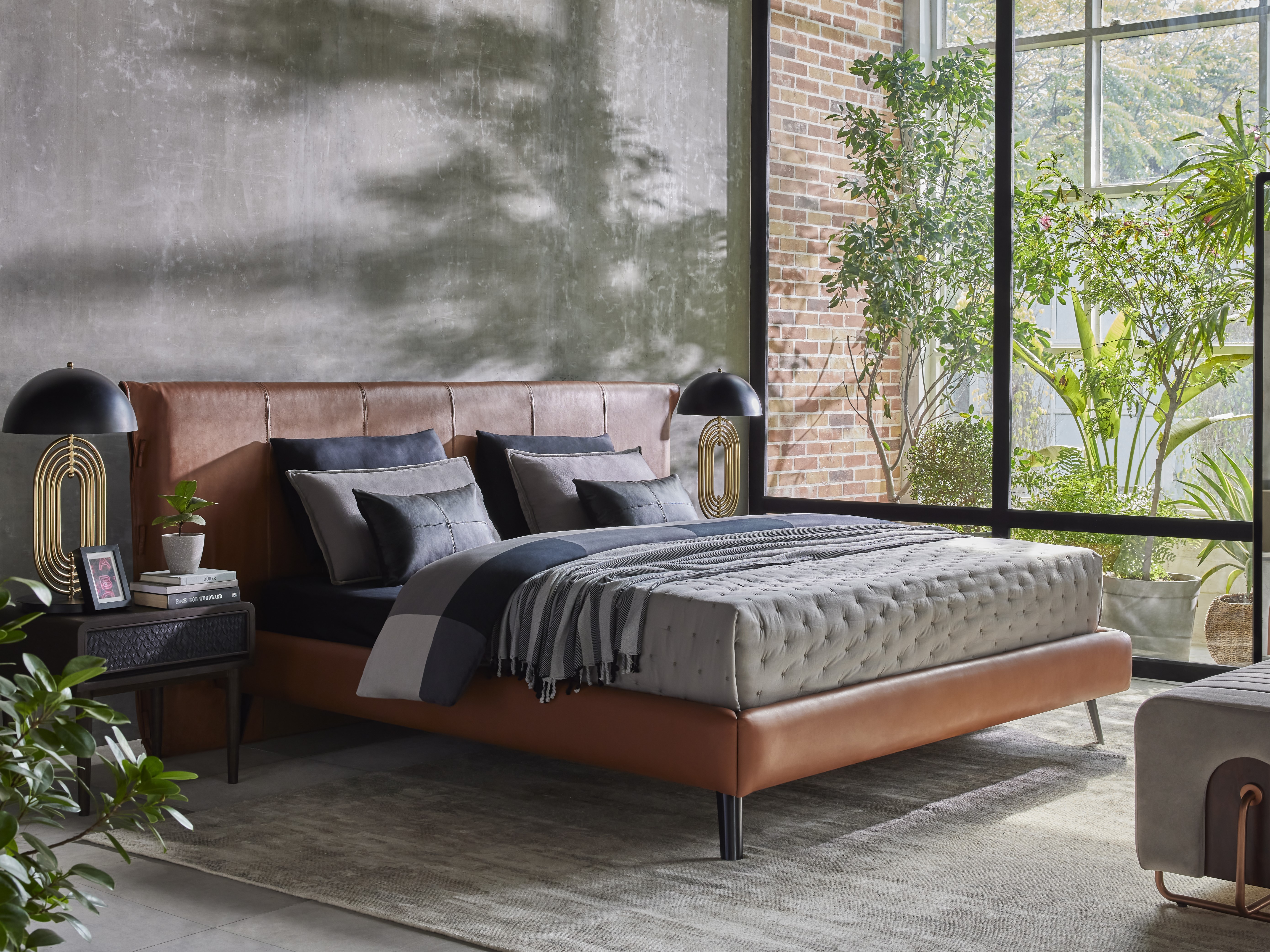 Modern bedroom with leather bed and natural light - Beautiful Homes