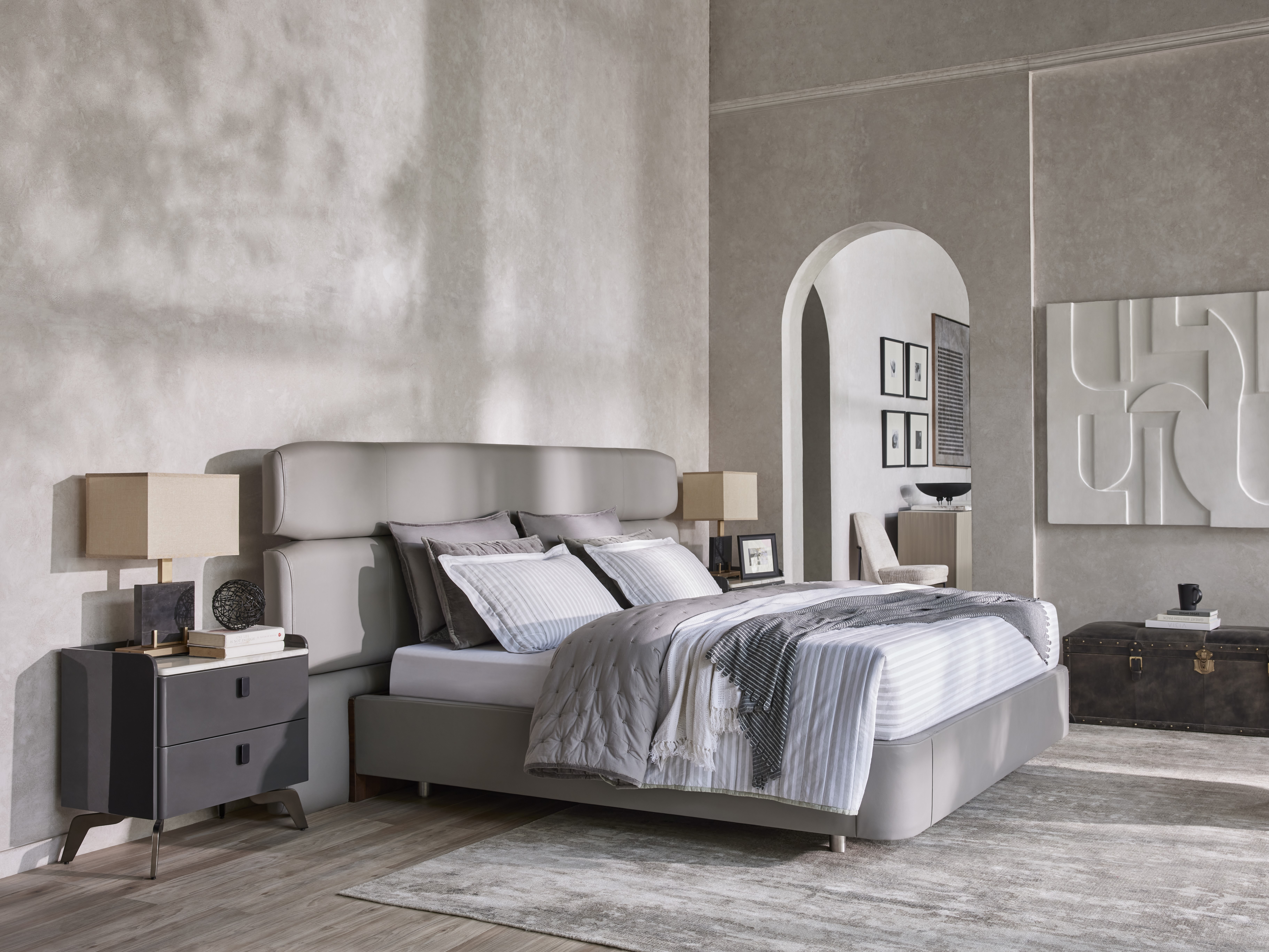 Minimalist bedroom with textured walls and grey bed - Beautiful Homes