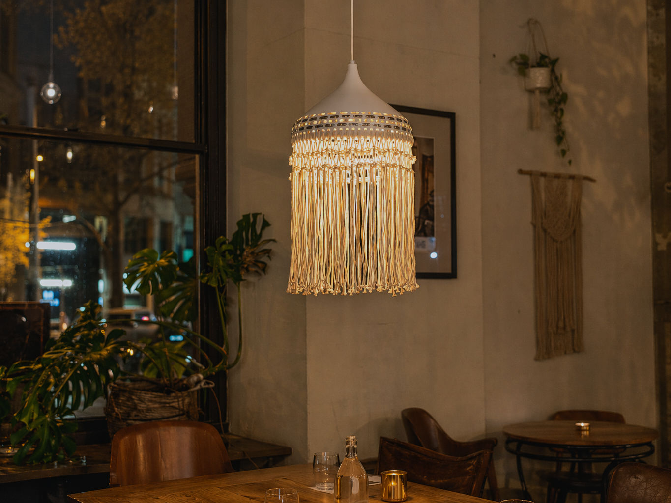 White pendant light with a cone-shaped shade, perforated metallic collar, and long cream macramé fringe - Beautiful Homes