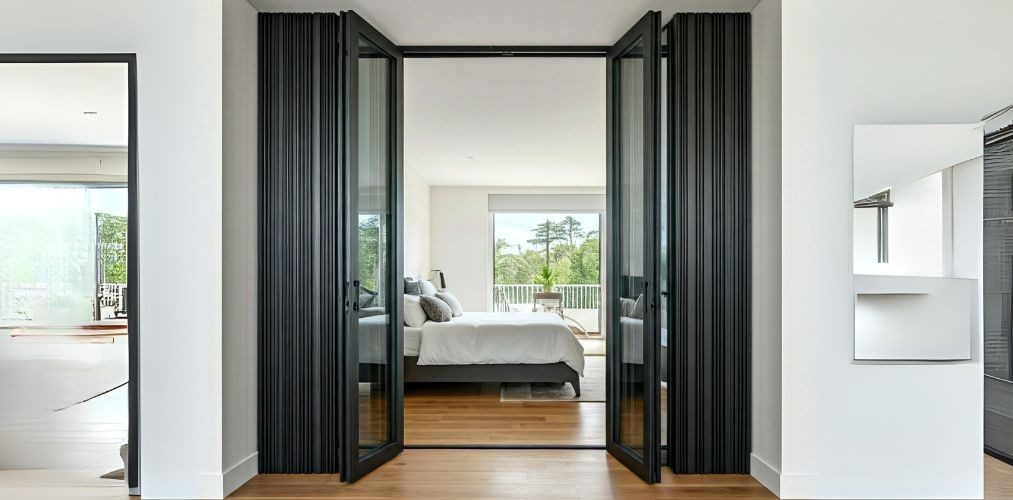 Folding glass wall with black frame and wooden floor - Beautiful Homes