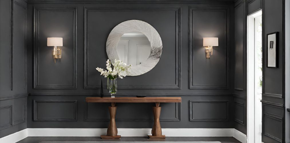 Modern foyer with dark grey wall paneling and circular mirror - Beautiful Homes