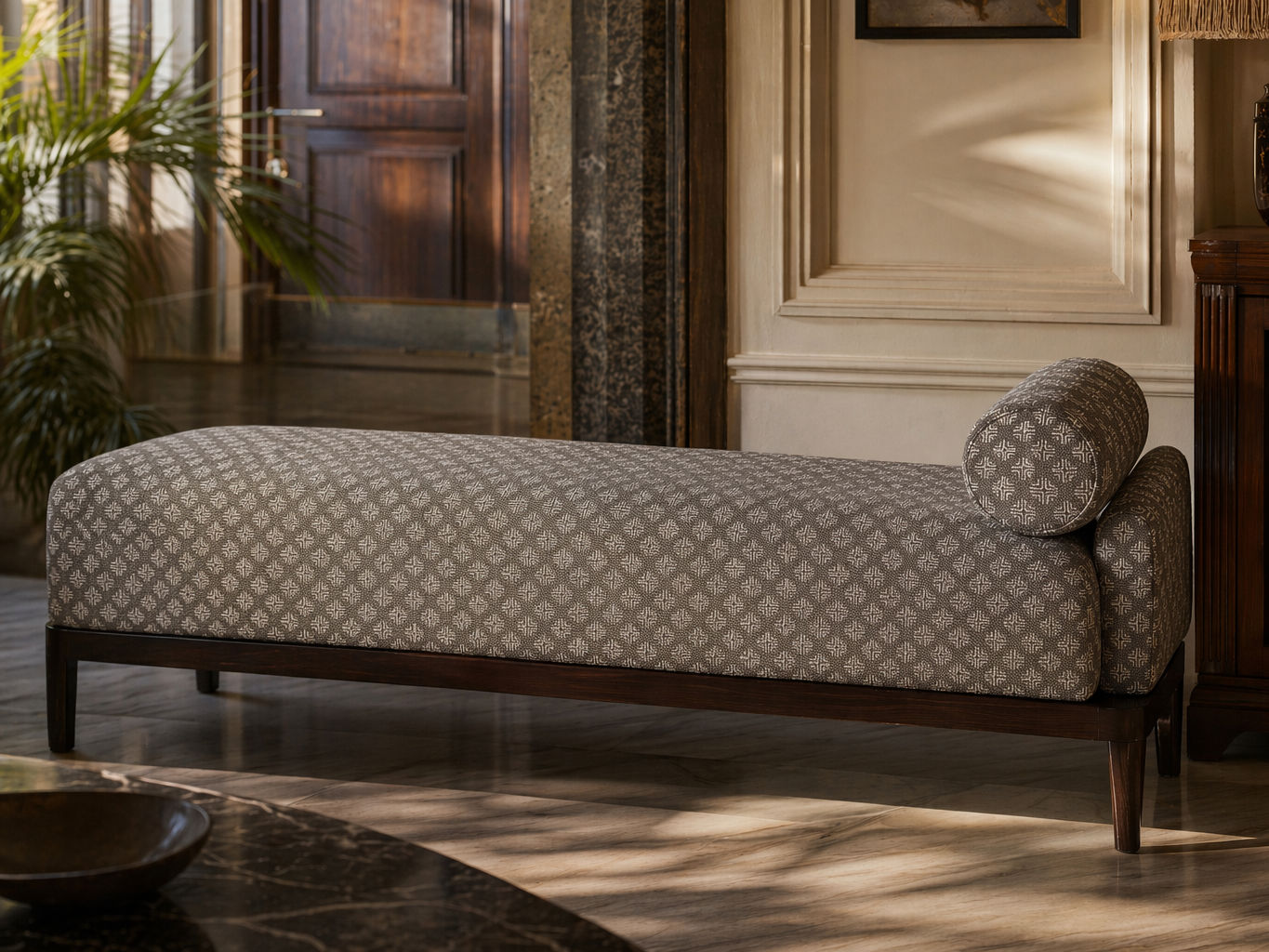Upholstered daybed with a grey and off-white geometric pattern, matching cylindrical bolster, and dark wood frame - Beautiful Homes