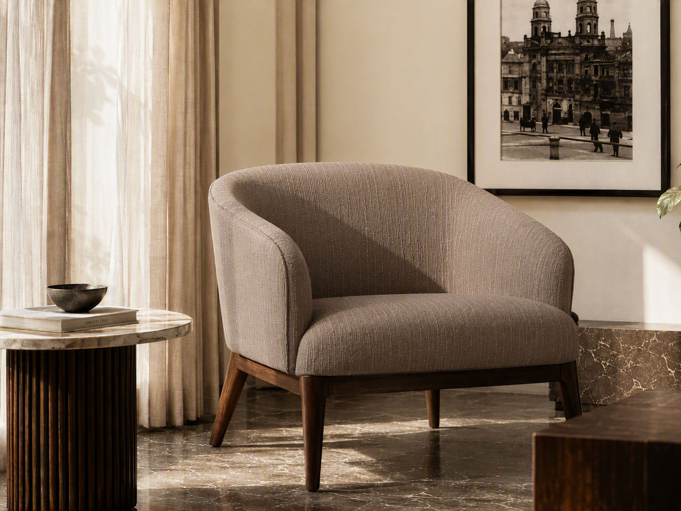 Low-profile tub armchair upholstered in textured taupe fabric with integrated curved arms and dark wooden legs - Beautiful Homes