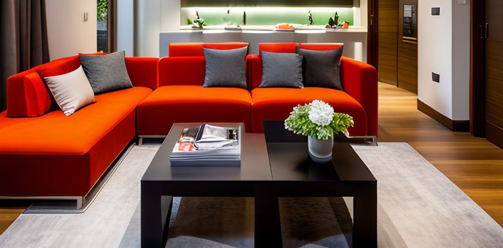 Living room design with orange L shaped sofa and black table-Beautiful Homes