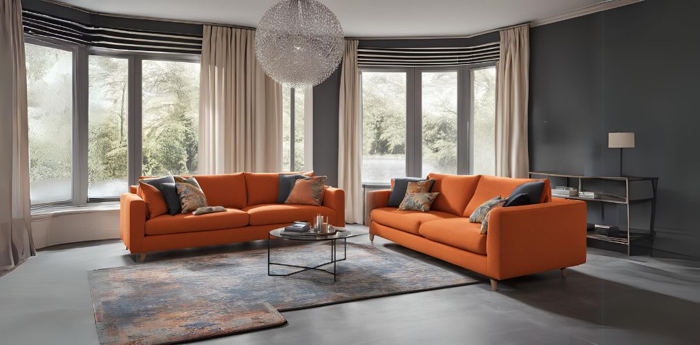 Contemporary living room with 3 seater orange upholstered sofas and round chandelier - Beautiful Homes