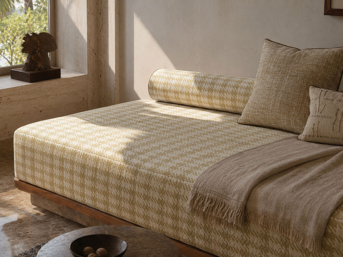 Low-profile daybed with a muted olive and cream houndstooth upholstered cushion, matching bolster pillow, neutral accent cushions, and a rich wooden base - Beautiful Homes