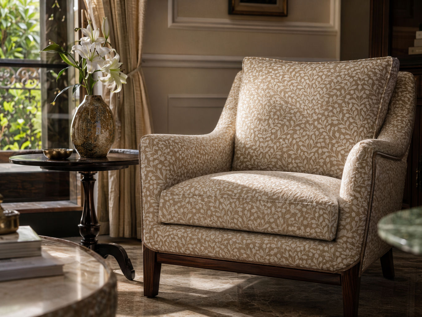 Upholstered armchair with a beige and cream botanical leaf pattern, plush cushioned seat, and dark polished wooden base - Beautiful Homes