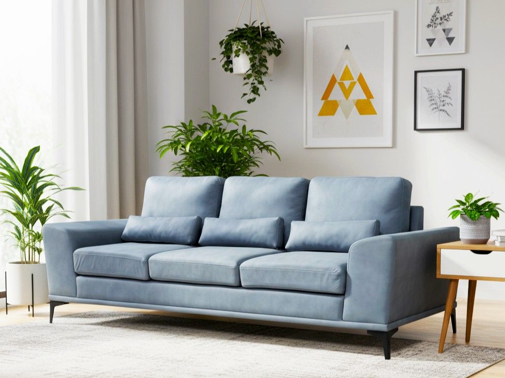 Contemporary living room featuring a light blue sofa, green plants, and abstract wall art - Beautiful Homes