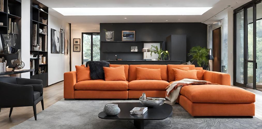 Modern living room with orange sectional sofa and black accent chair - Beautiful Homes