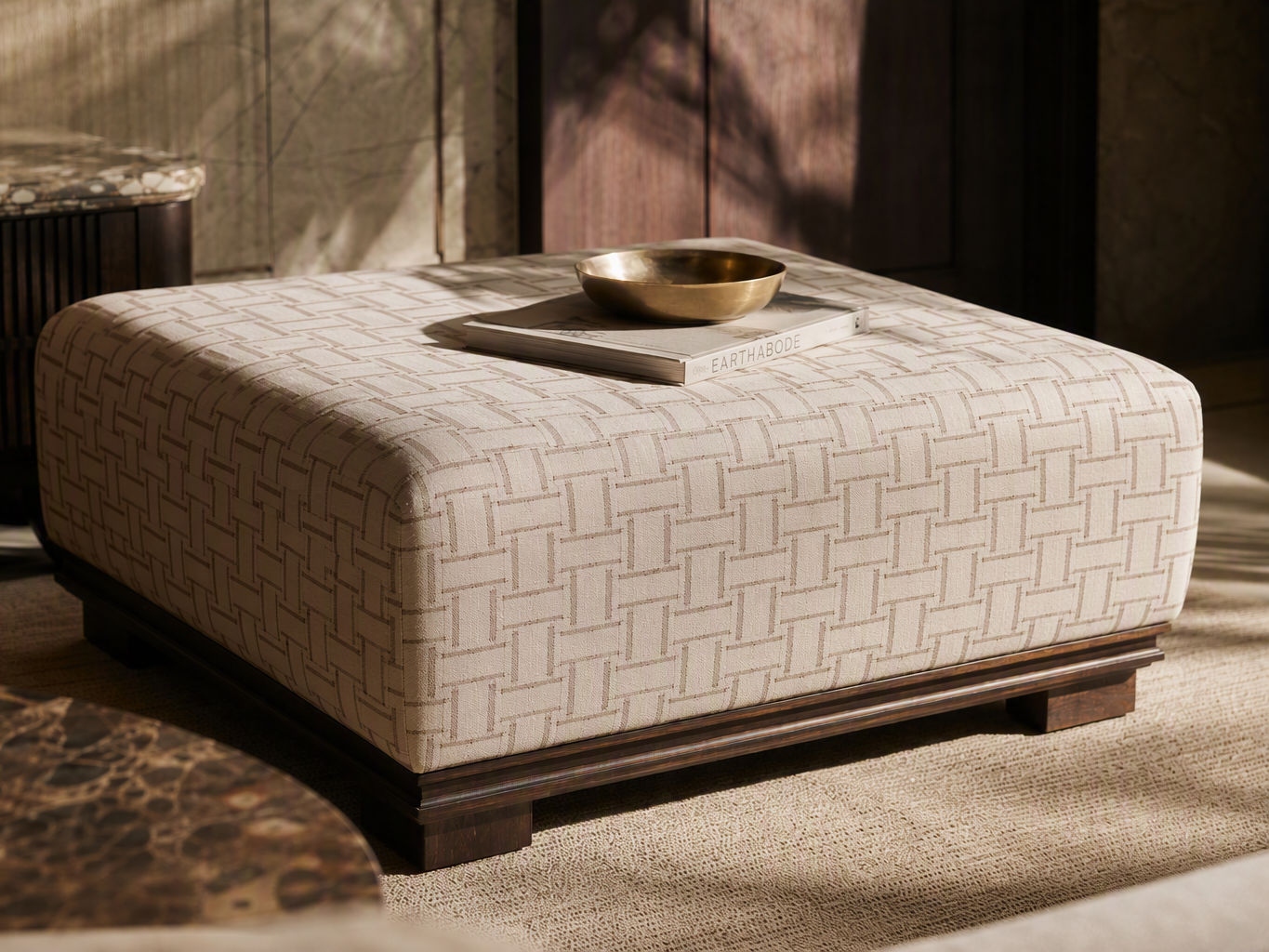 Square ottoman upholstered in cream fabric with a taupe geometric weave - Beautiful Homes