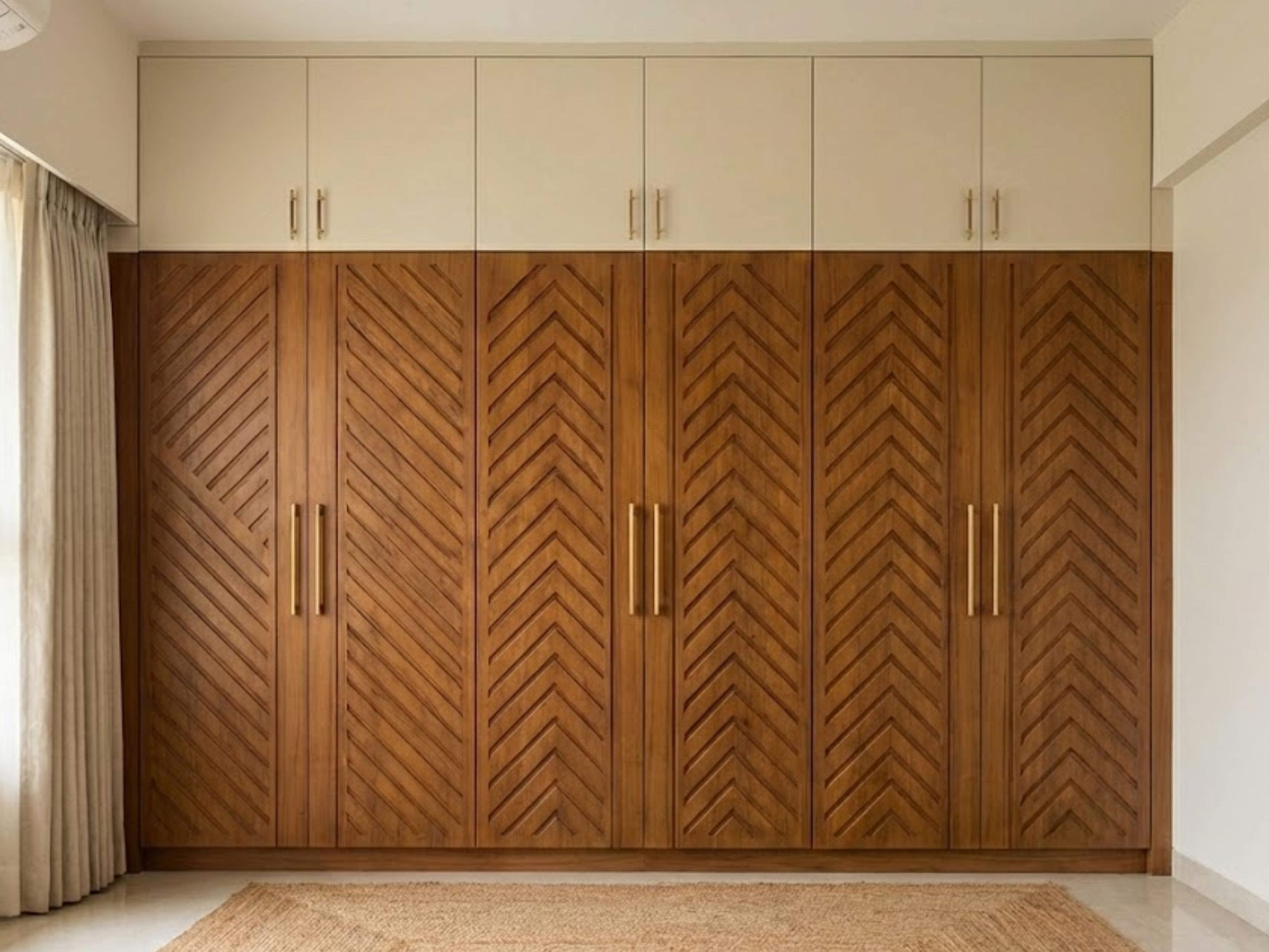 Chevron wooden wardrobe with gold handles and neutral cabinets - Beautiful Homes