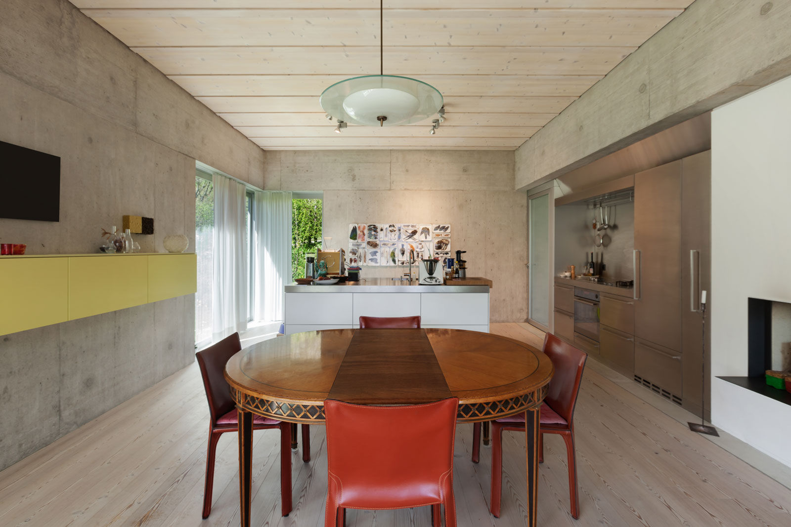 The concrete wall complements the steel finish of the dining cum kitchen space - Beautiful Homes