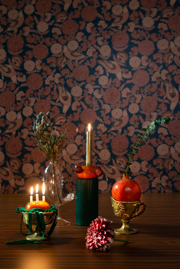 A Christmas table decoration by using apples, plums, and pomegranates
