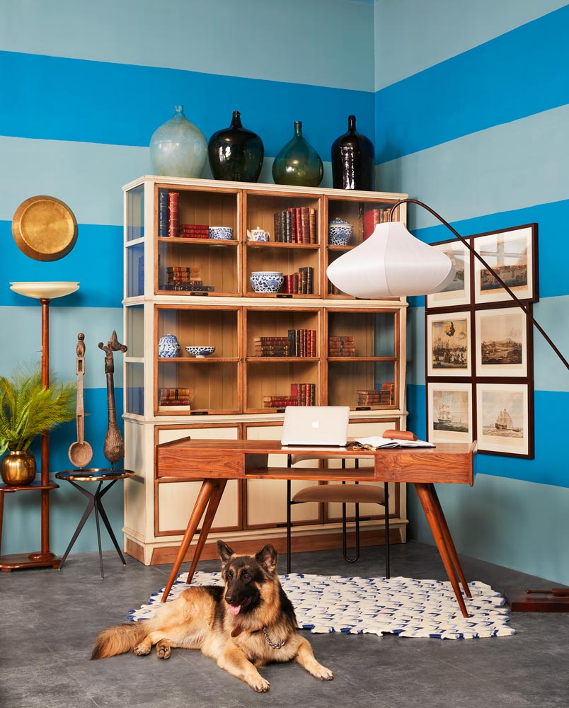 Library Living Room Design With Wooden Cabinet Behind The Table and Blue Paint - Beautiful Homes