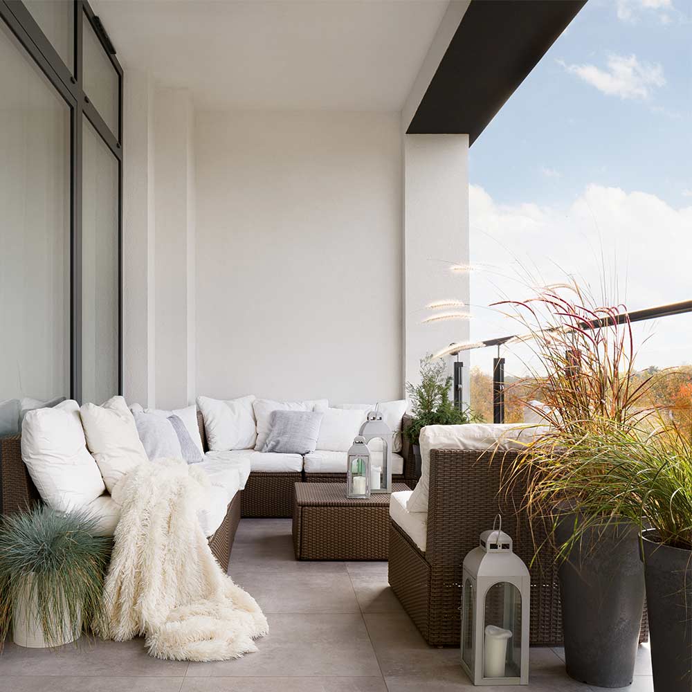 Cosy small balcony ideas with sectional sofa & centre table - Beautiful Homes
