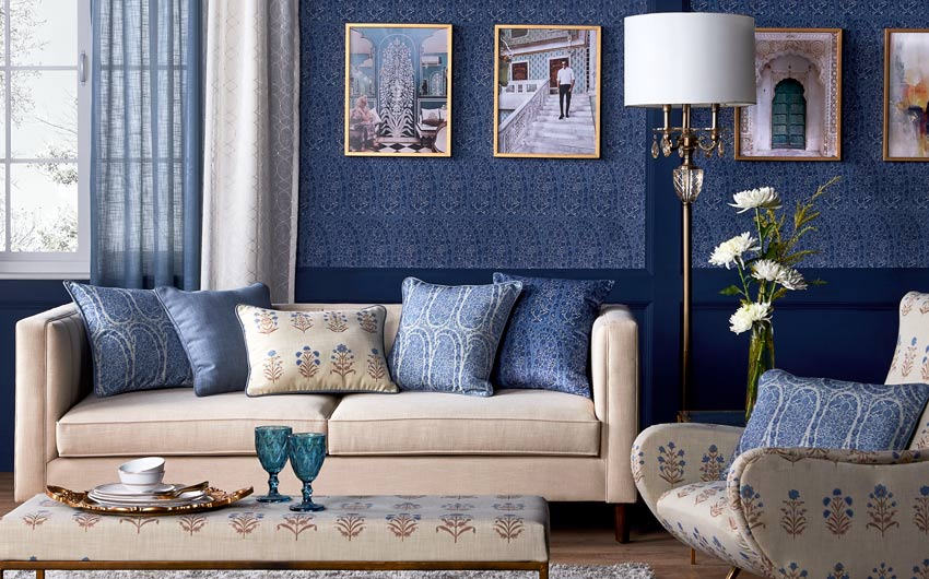 A room with a blue wallpaper and a cream sofa