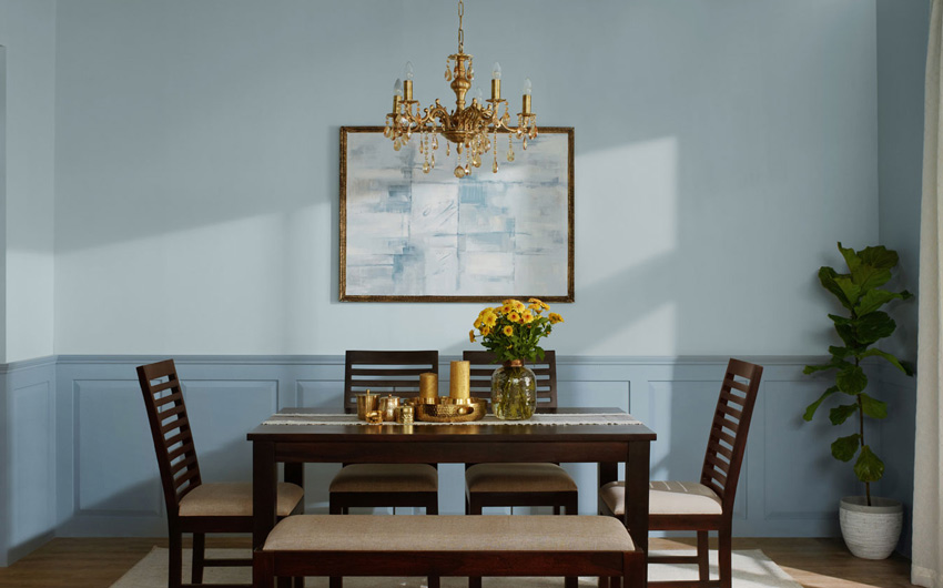 A blue dining room with a wooden dining table and a chandelier