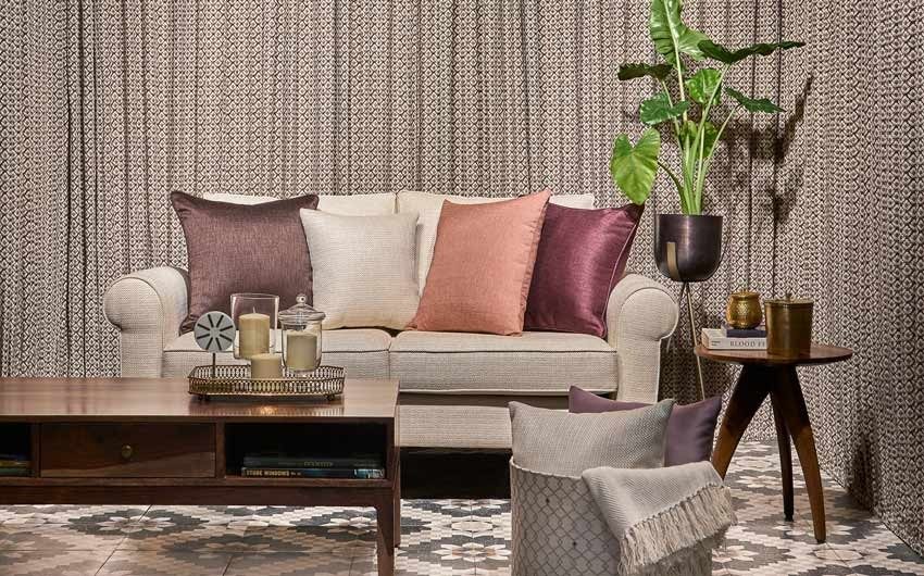 A living room with an off white sofa and a side table