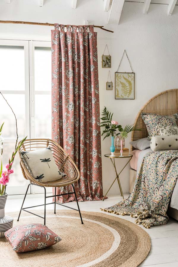 Tall curtain design with pastel colours in a different print from the linen on the bed