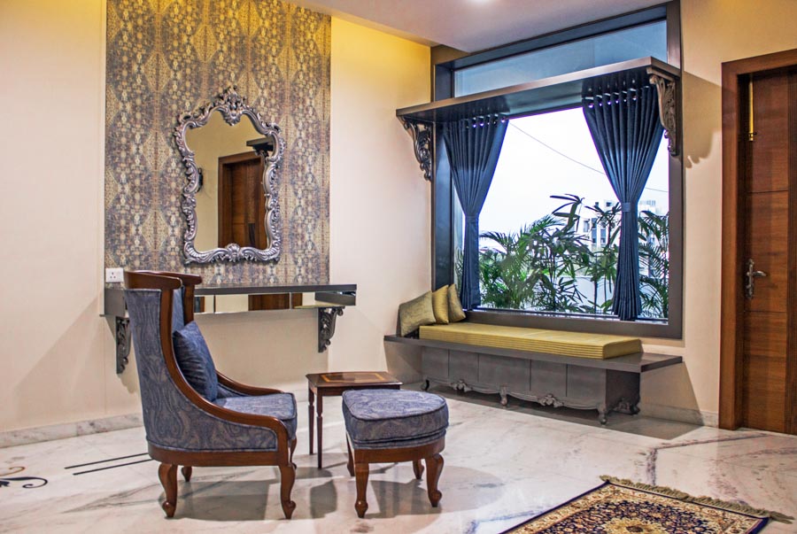 Monochromatic room with matching blue curtain design, cobalt-printed armchair and ottoman