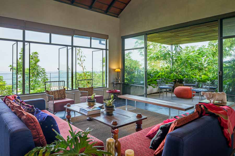  A living room with red and blue sofas, a coffee table and big windows