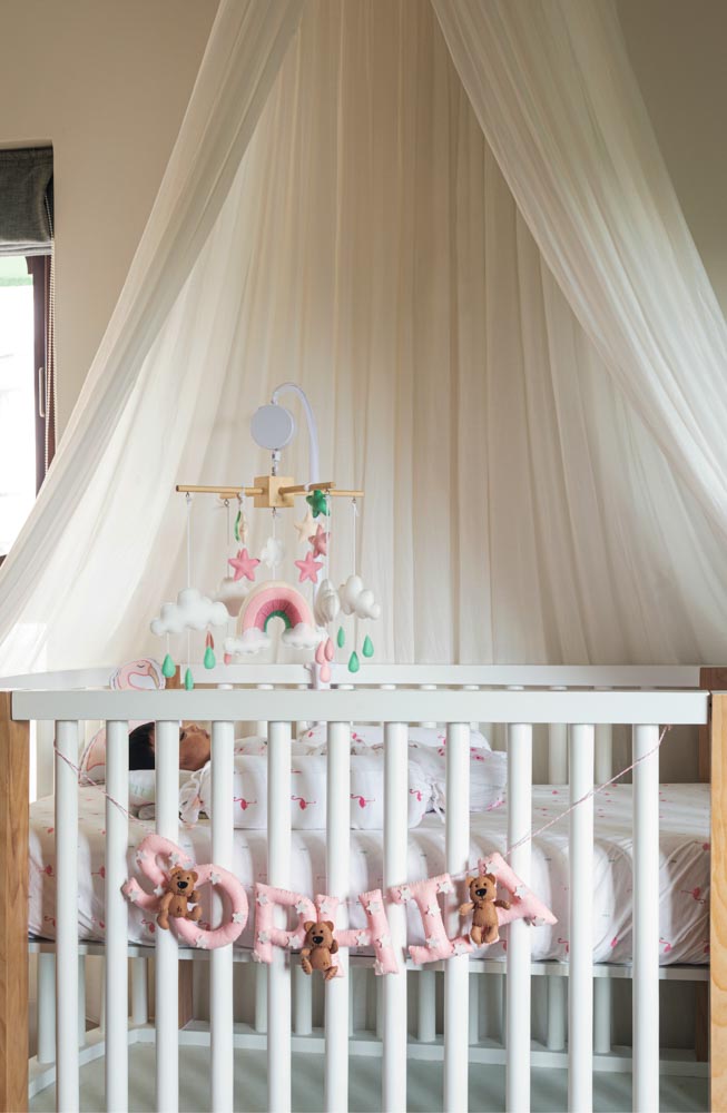 A white wooden cot with 'Sophia' written on it
