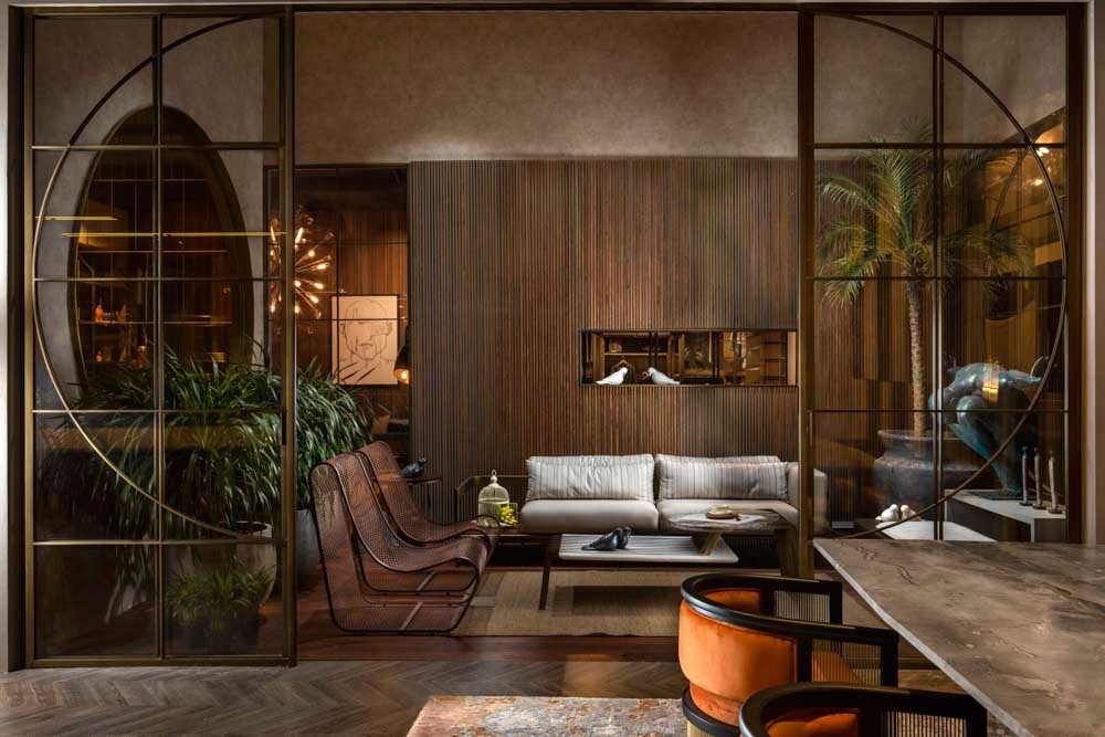 Spacious living room with wood work & gold glass partition for door design - Beautiful Homes
