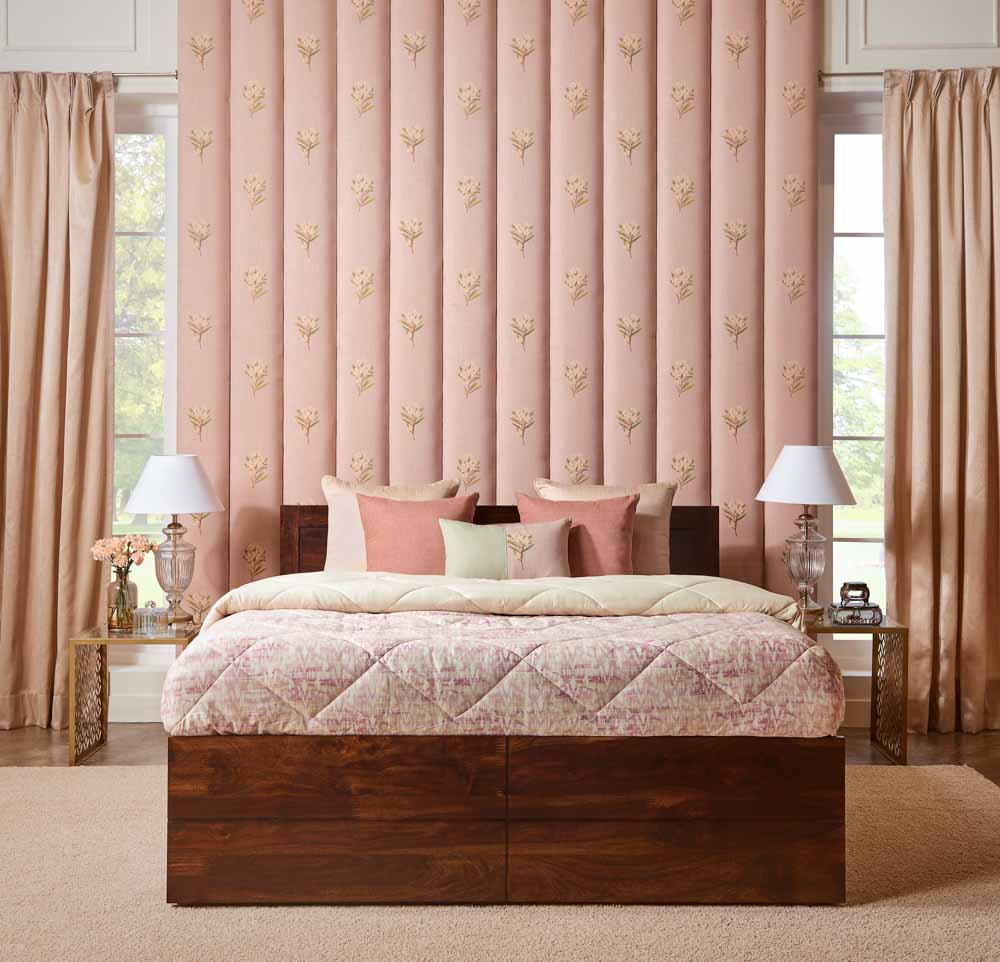 A bedroom with pink walls, a wooden bed, side tables with lamps placed on them