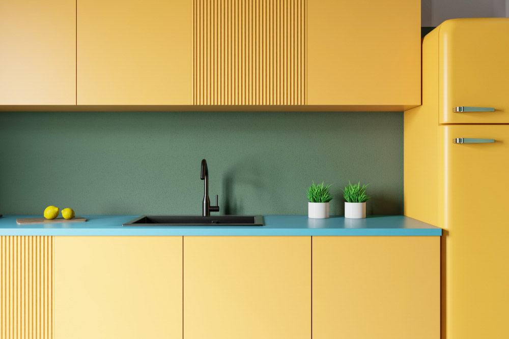 Modular kitchen with solid yellow, green colour palette & blue kitchen countertop - Beautiful Homes