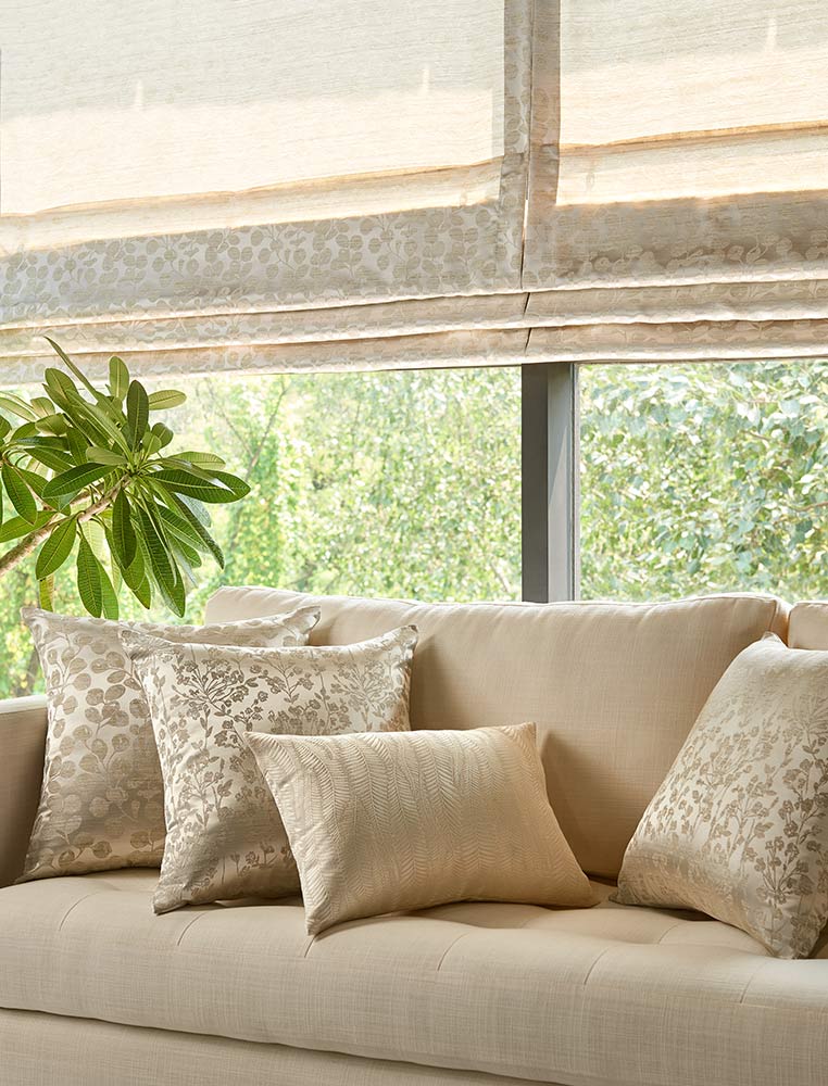 A sofa with cushions and blinds at the back