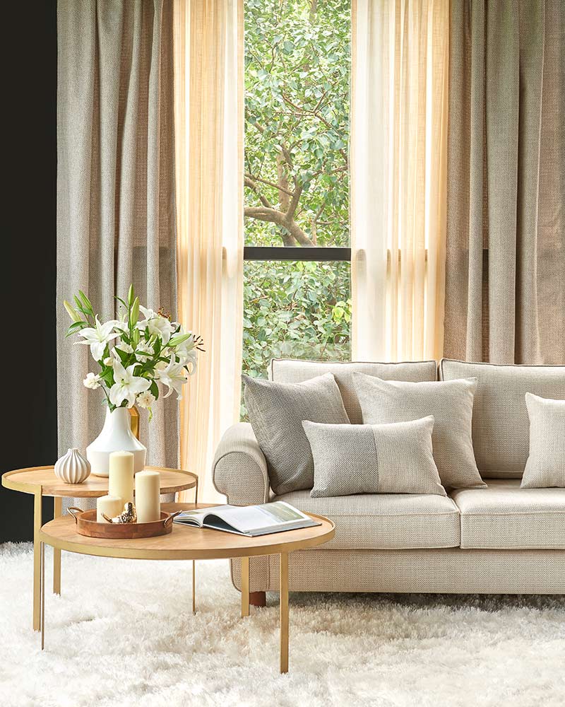 A sheer fabric curtain with sofa and coffee table