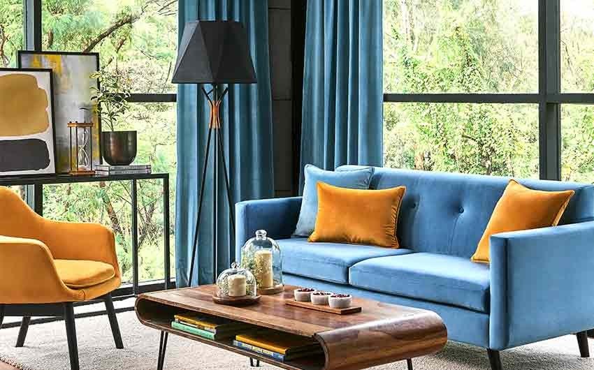 Living room with full-length glass windows, a sofa, coffee table, and artwork on a console