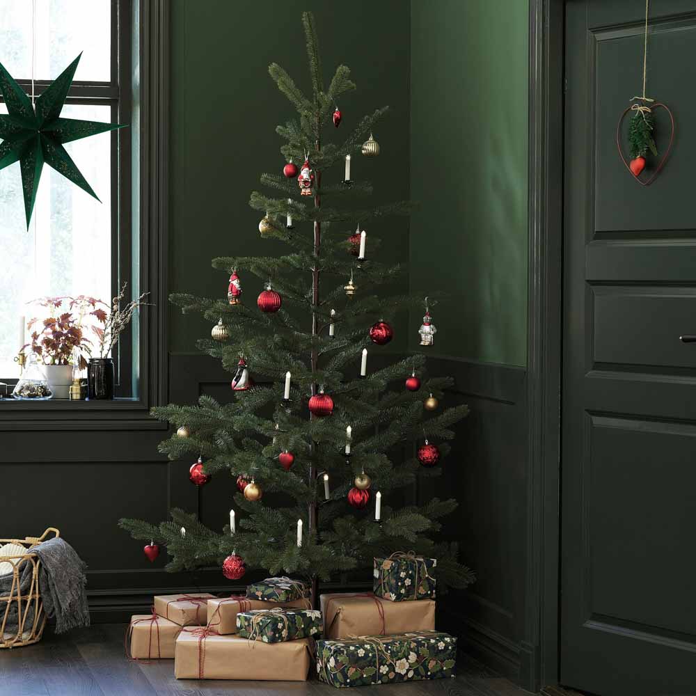A christmas tree in the corner of a room