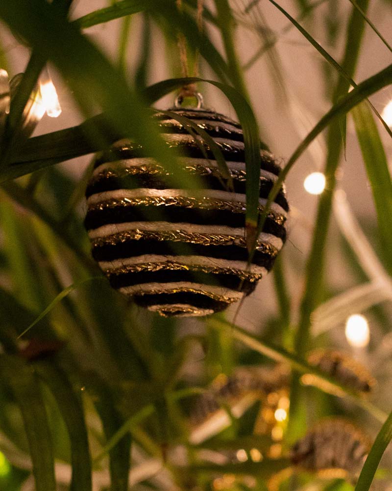 A round black and gold christmas ornament