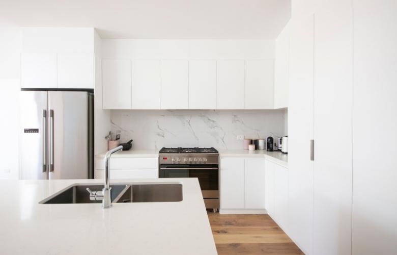 White modular kitchen with built-in microwave, gas stove & refrigerator - Beautiful Homes