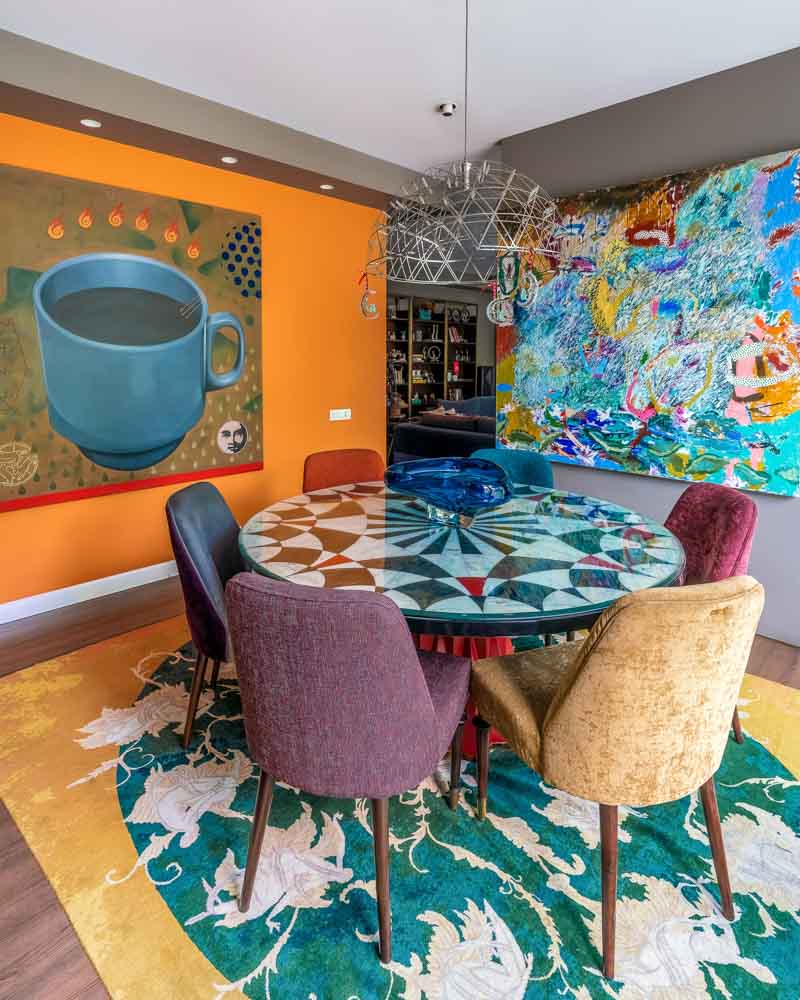 Vibrantly coloured accent wall with solid-coloured chairs & patterns - Beautiful Homes