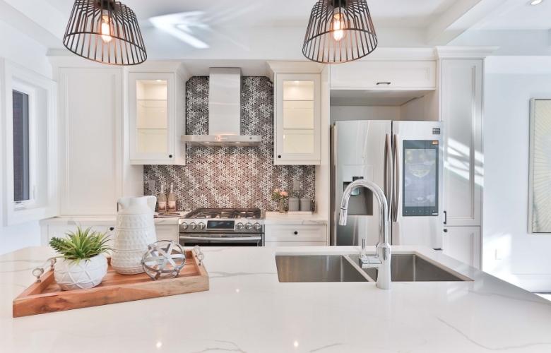 An all white modular kitchen interior design with a spacious kitchen counter - Beautiful Homes