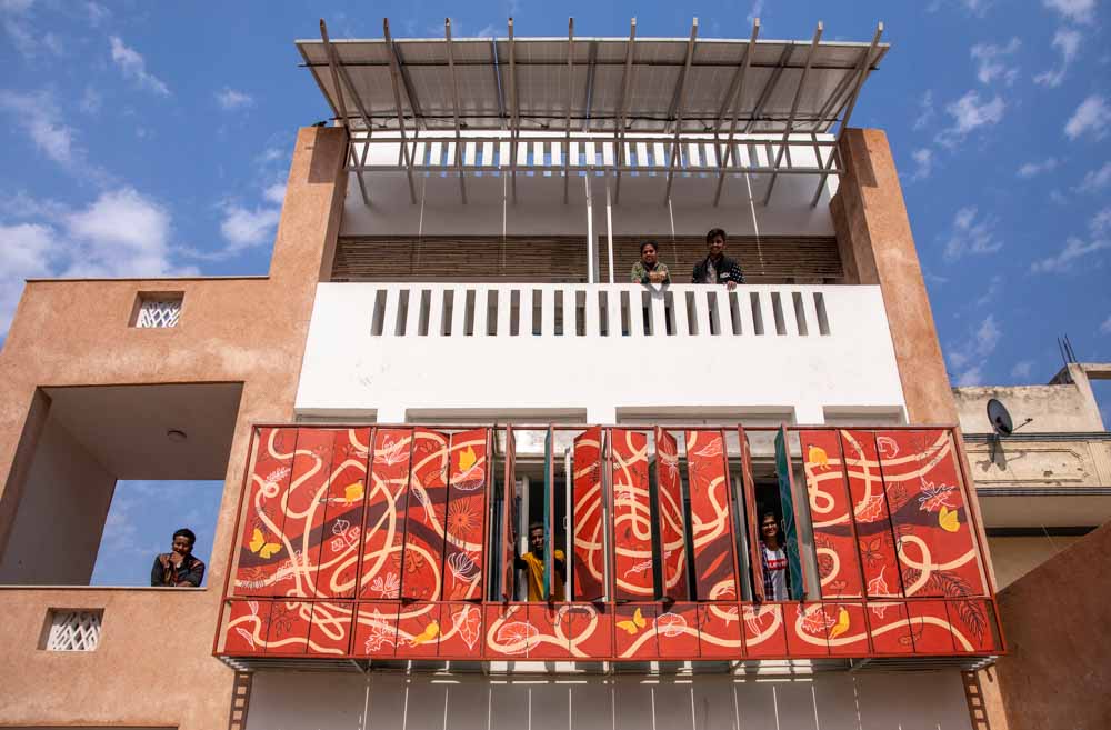 A home with a white balcony and an adjustable colourful structure - Beautiful Homes