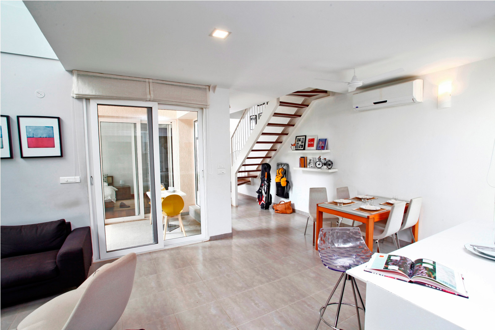 The space under the staircase can be fitted with a study or shelves to hold frames and accessories - Beautiful Homes