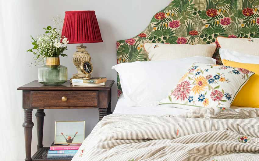 Bed Design With a Headboard Cover in a Floral Fabric, Bedside Table and Lamp - Beautiful Homes