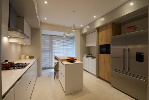 Spacious modular kitchen with a refrigerator unit & kitchen cabinets for storage - Beautiful Homes