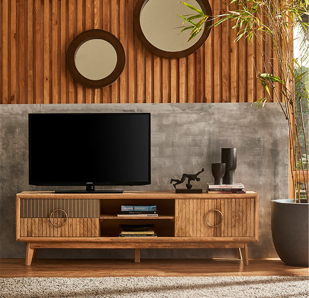 A wooden TV unit placed against a concrete wall