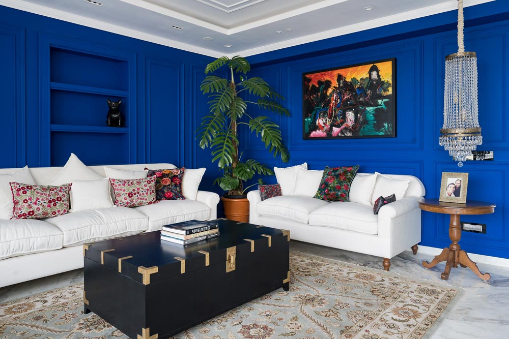 A beautiful blue living room design paired with pearl grey colour walls & a big houseplant - Beautiful Homes