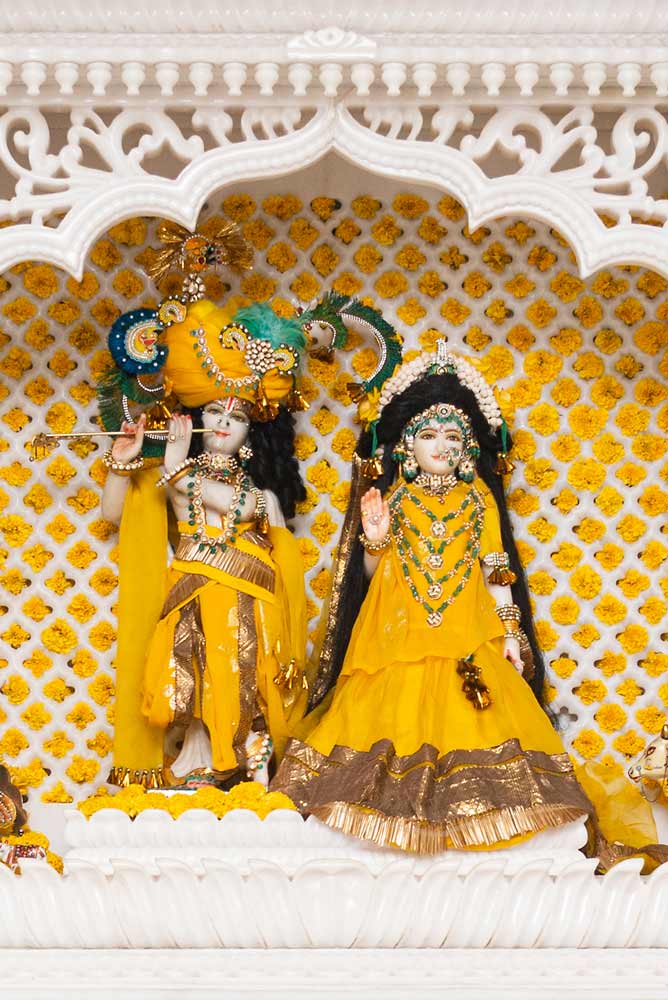 A couple of idols of Radha and Krishna clad in yellow cloth